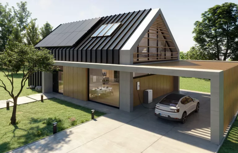 Ein modernes Haus mit Wallbox im Carport und PV-Anlage auf dem Dach. Im Carport wird gerade ein E-Auto geladen.